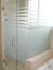 square frameless shower enclosure with striped privacy glass and swinging door
