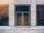 a grey glass storefront door surrounded by beige bricks