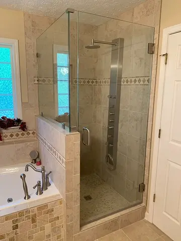 Shower enclosure with full height frameless glass door and frameless glass panels on a half-wall installed by Glass Doctor of Nashville.